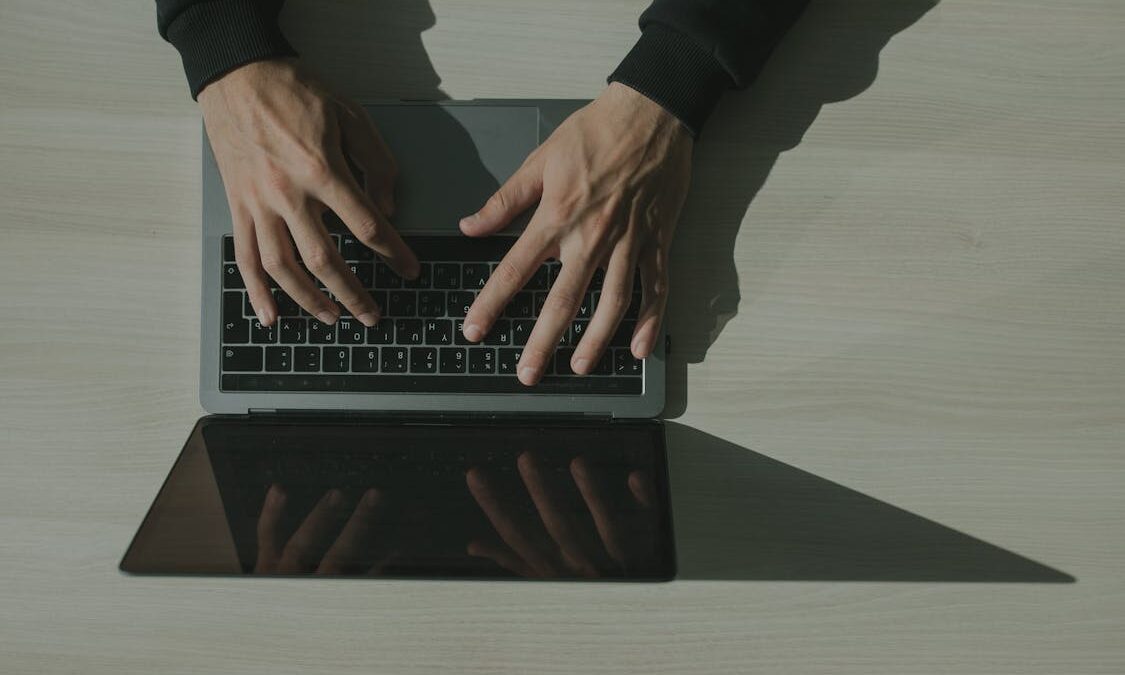 Persoon typt op een laptop na een waarschuwing over het Basic-Fit datalek en phishing-aanvallen