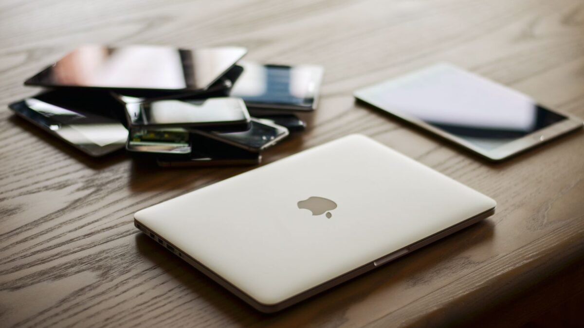Laptop, tablet en smartphone op een bureau, symbool voor phishingaanvallen die zich aanpassen aan het apparaat