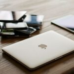 Laptop, tablet en smartphone op een bureau, symbool voor phishingaanvallen die zich aanpassen aan het apparaat