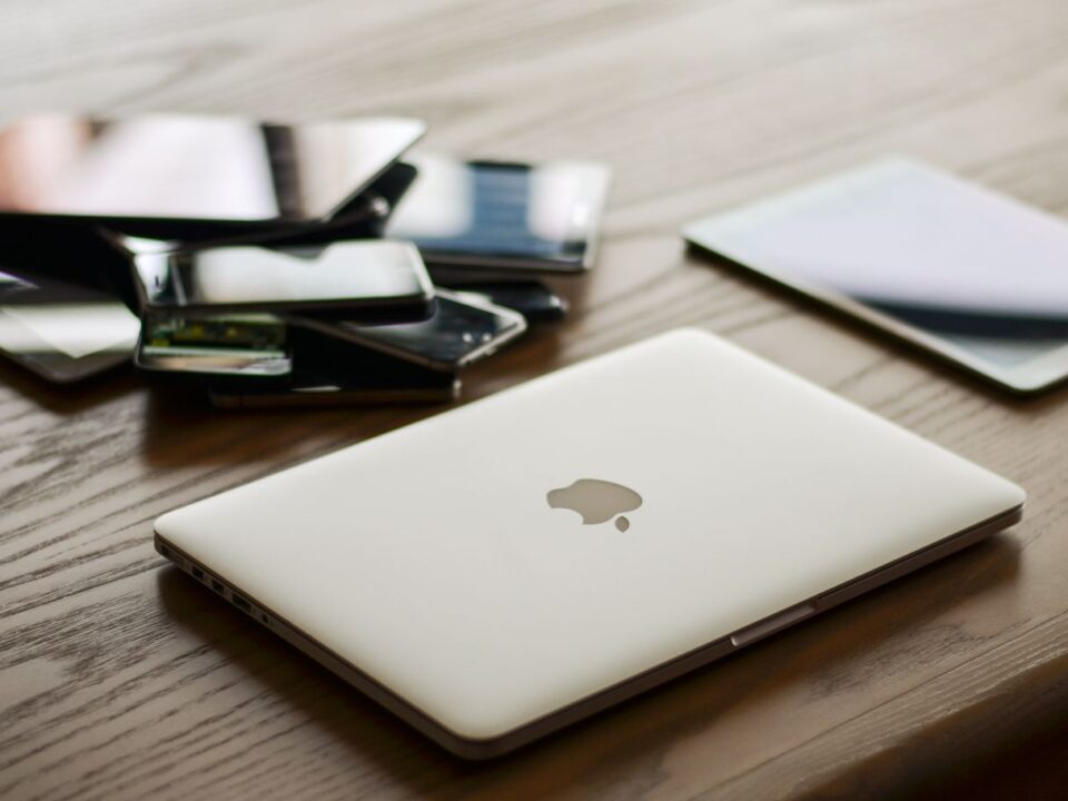 Laptop, tablet en smartphone op een bureau, symbool voor phishingaanvallen die zich aanpassen aan het apparaat