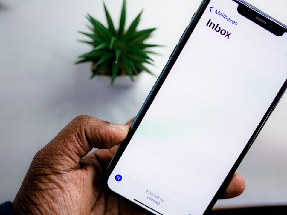 Persoon bekijkt e-mailinbox op smartphone, symbool voor waakzaamheid tegen phishingmails na een datalek