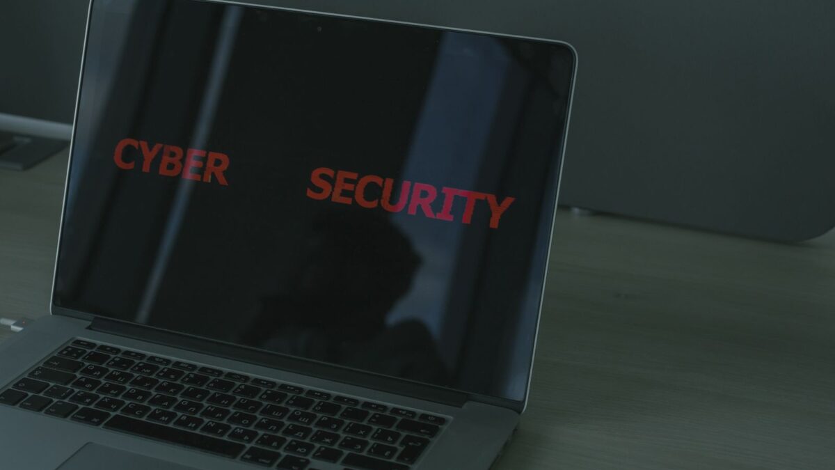 Laptop met de rode tekst CYBER SECURITY op het scherm, symbool voor phishing via gehackte websites